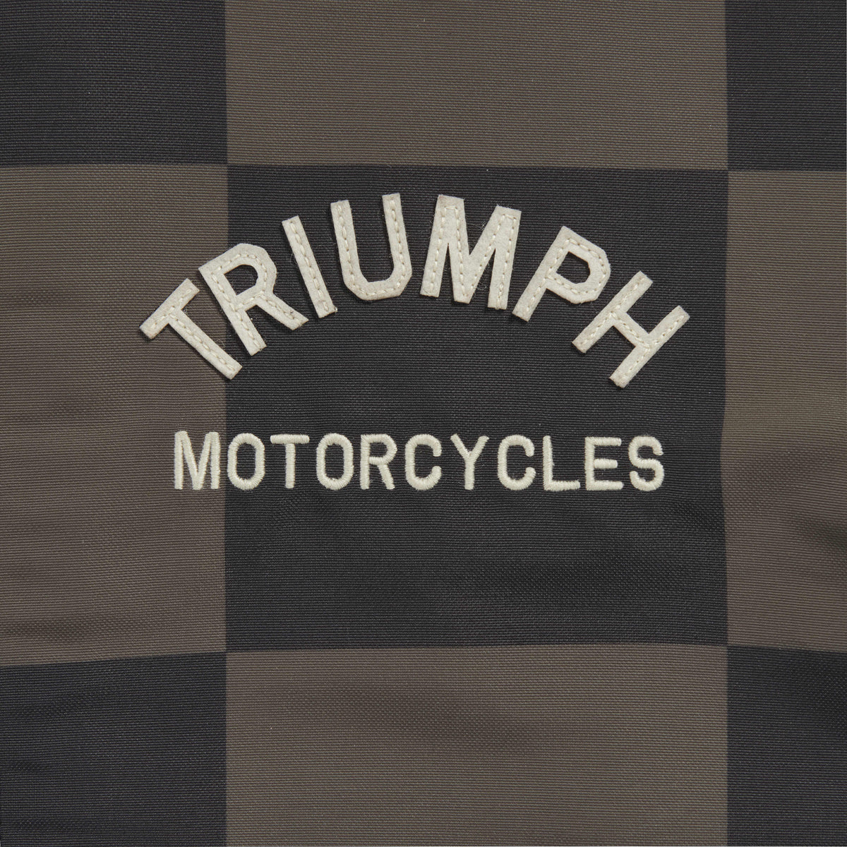 Triumph Carter Checkerboard Jacket, close-up of the chest logo on checkerboard fabric